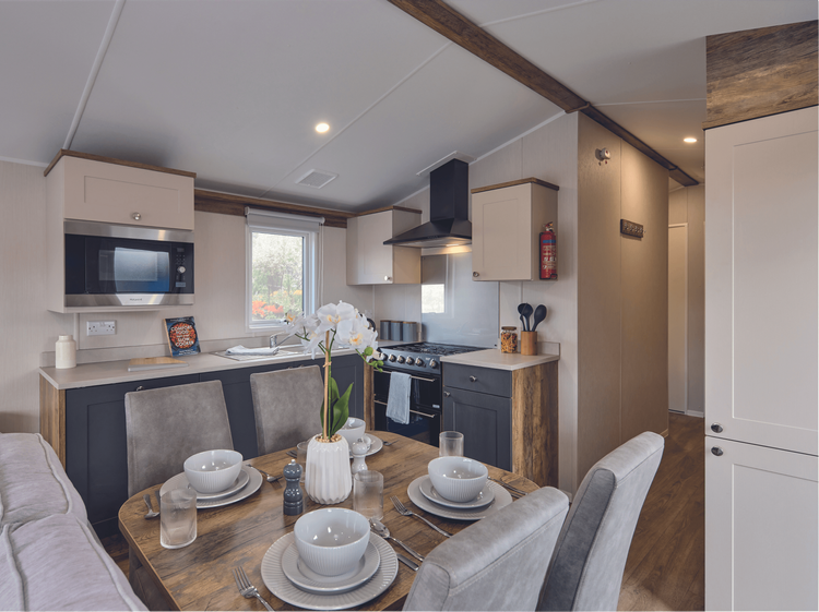 The Willerby Malton kitchen has cream and grey cupboard doors with a matching cream worktop.