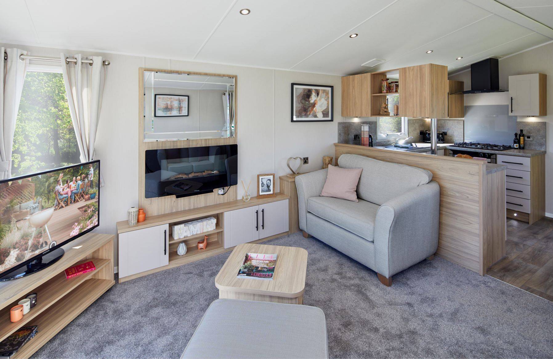 The Willerby Manor lounge has freestanding sofas with a matching footstool, an oak effect coffee table and a media unit.