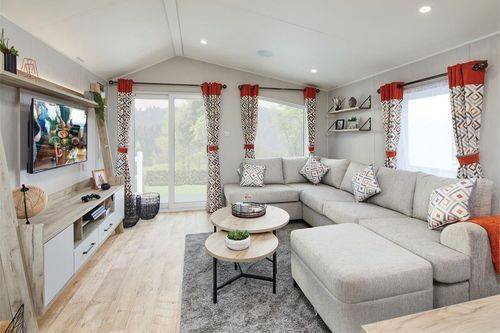 The Willerby Astoria lounge with an L-shaped freestanding comfy sofa, a round coffee table and a matching oak effect media unit.