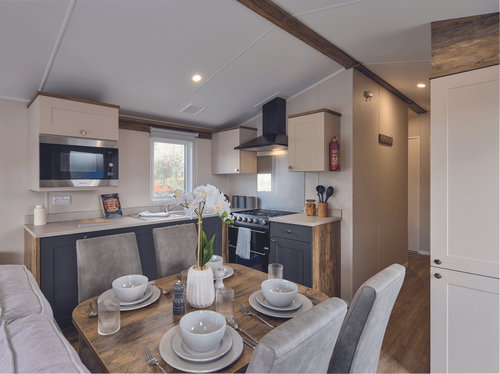 The Willerby Malton kitchen has cream and grey cupboard doors with a matching cream worktop.