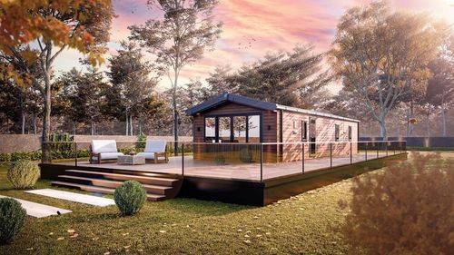 The Willerby Gainsborough exterior in brown is sited with brown wooden decking on a field.