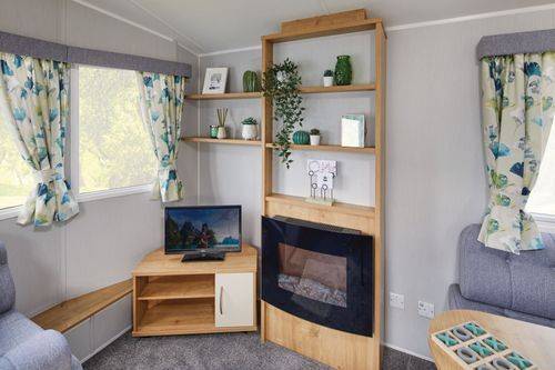 The Willerby Ashurst oak effect media unit with shelving and an electric fire.