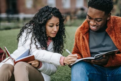 Cheerful students studying together in campus park; Photo by Keira Burton from Pexels