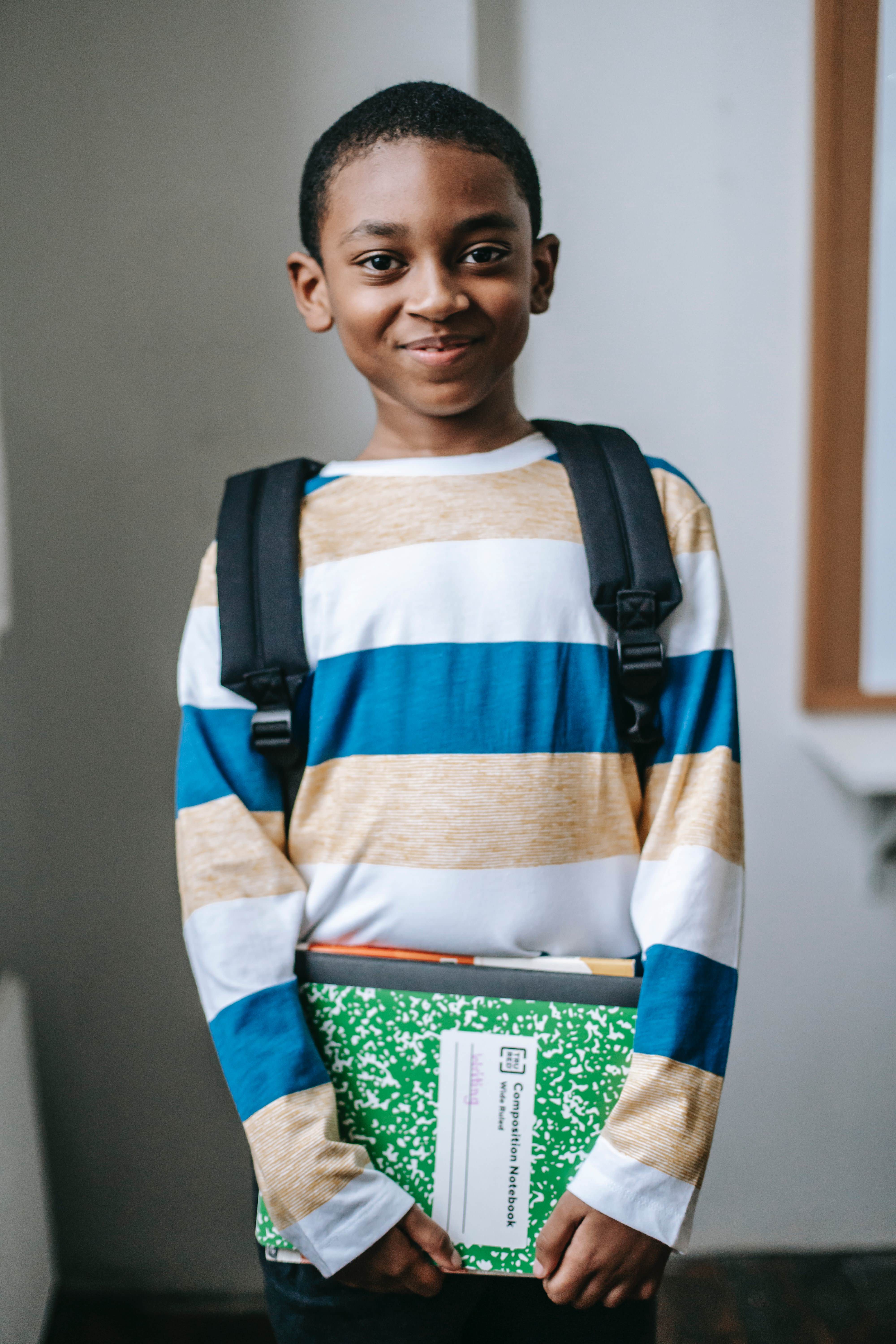 Smiling child standing in classroom and looking at camera; Photo by Katerina Holmes from Pexels
