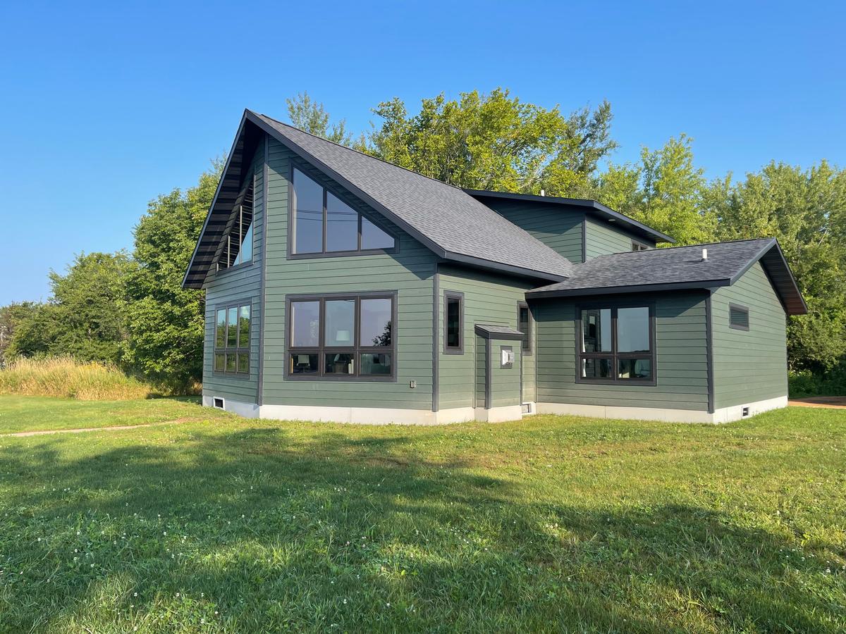 Chalet style modular home with green siding and black roof built by Wisconsin Homes.