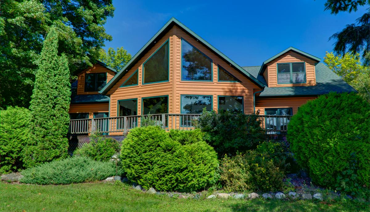 Chalet with large front windows and wraparound deck
