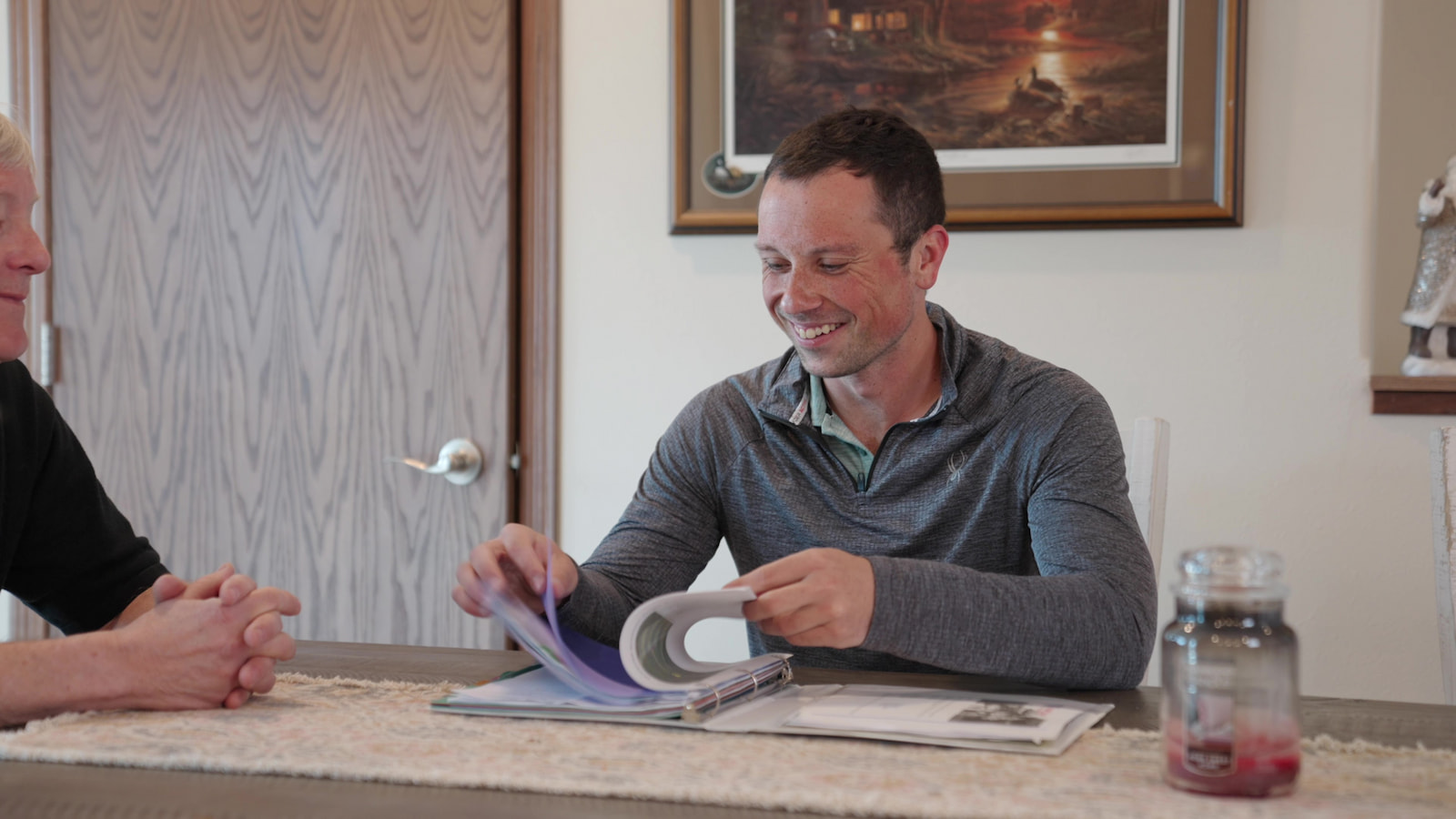 Wisconsin Homes representative reviewing floor plan binder with a client during a home consultation.