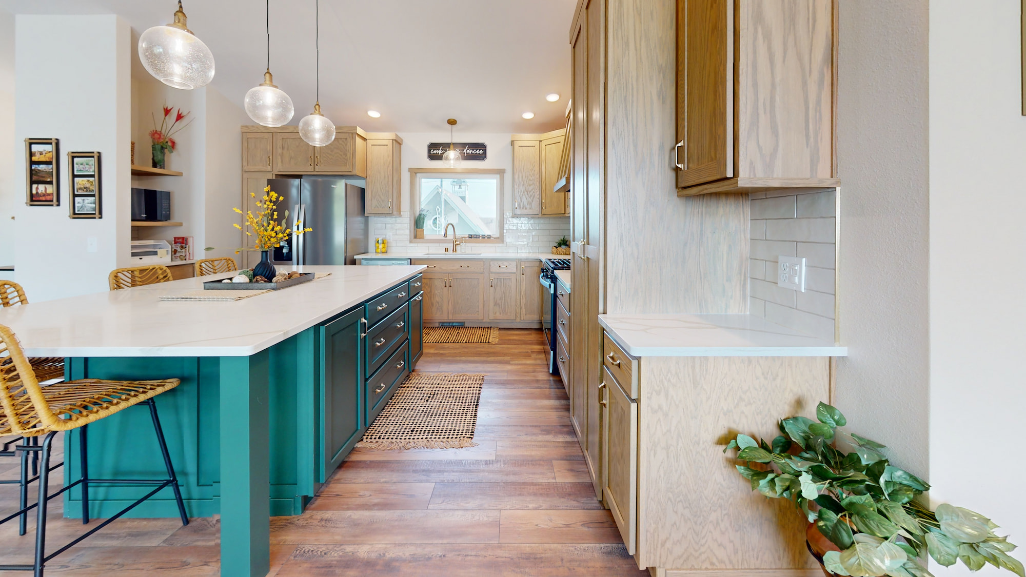 Modern kitchen with green island, pendant lighting, and light wood cabinets in a Wisconsin Homes modular home.