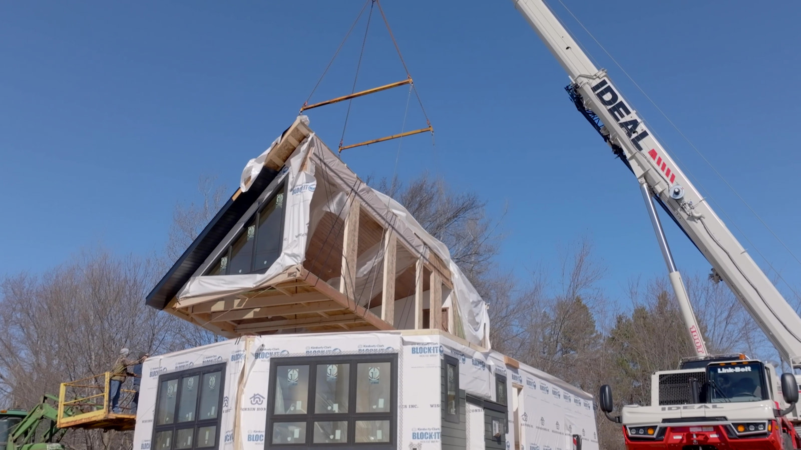 Modular chalet home section being lifted into place by crane for Wisconsin Homes installation.