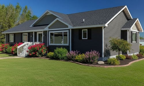 Dark gray ranch-style modular home with white trim, front steps, and gable roof by Wisconsin Homes.