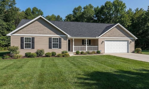 Beige ranch-style modular home by Wisconsin Homes with black shutters, white porch railing, and attached garage in Marshfield, WI.