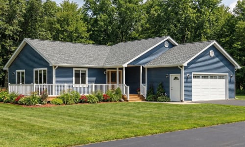 Blue cottage-style modular home by Wisconsin Homes in Marshfield, WI with white trim, front porch, and attached garage.