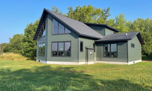 Chalet style modular home with green siding and black roof built by Wisconsin Homes.