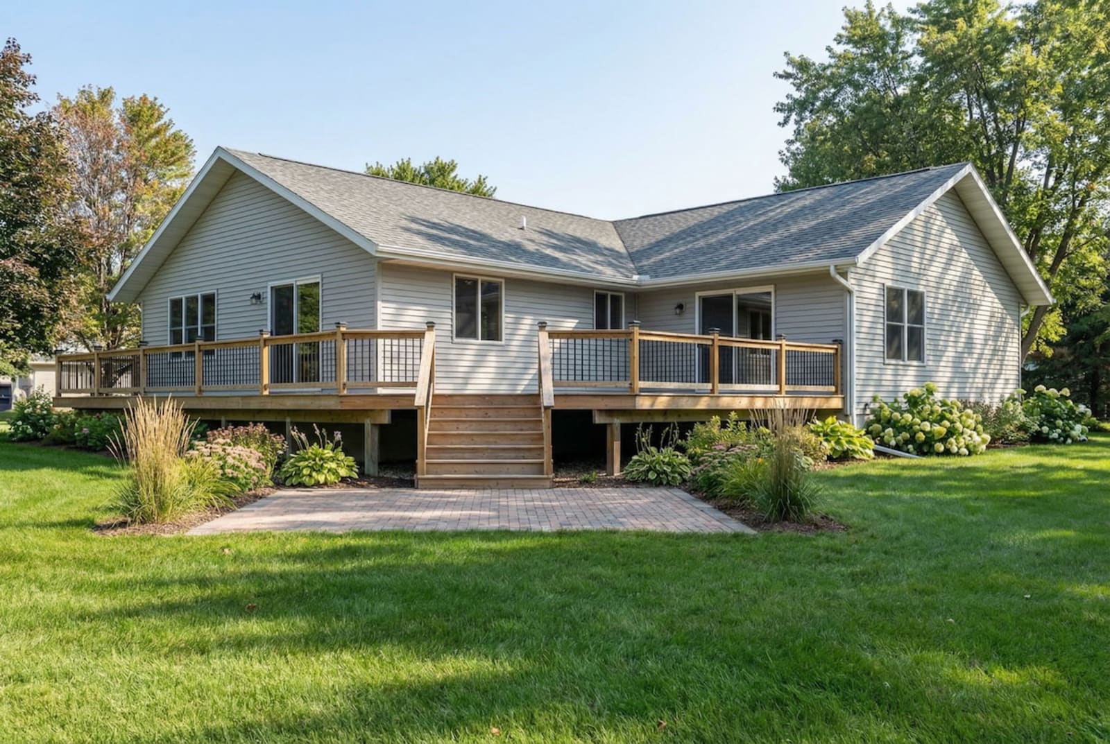 Light-toned cottage-style modular home by Wisconsin Homes in Marshfield, WI with raised deck and patio landing.