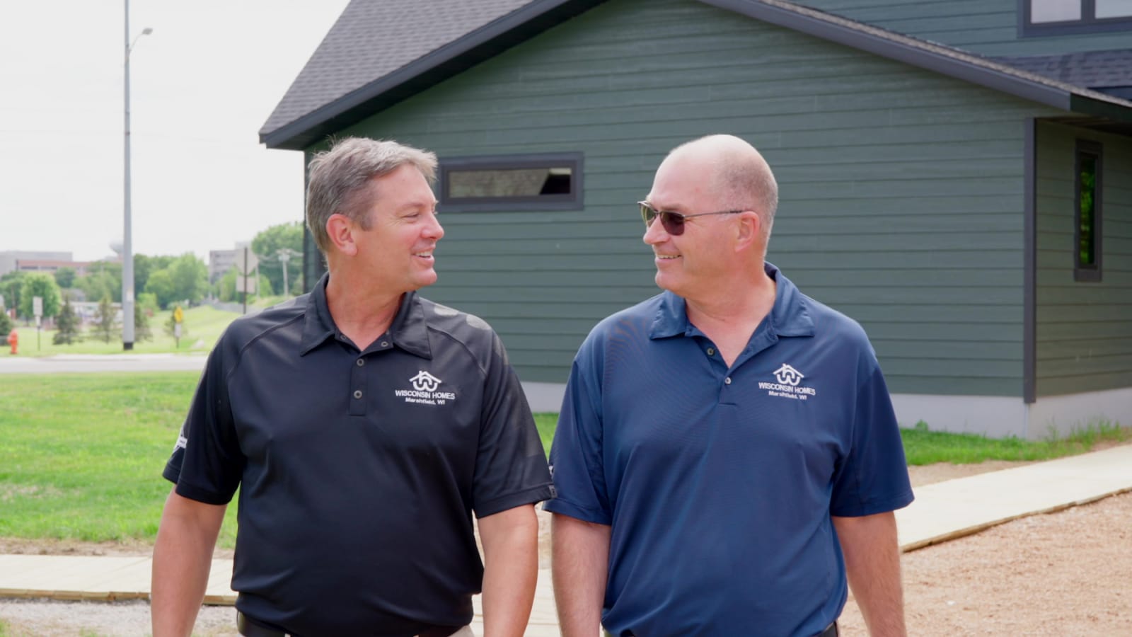 Wisconsin Homes team members smiling outside a finished modular model home in Marshfield, WI.