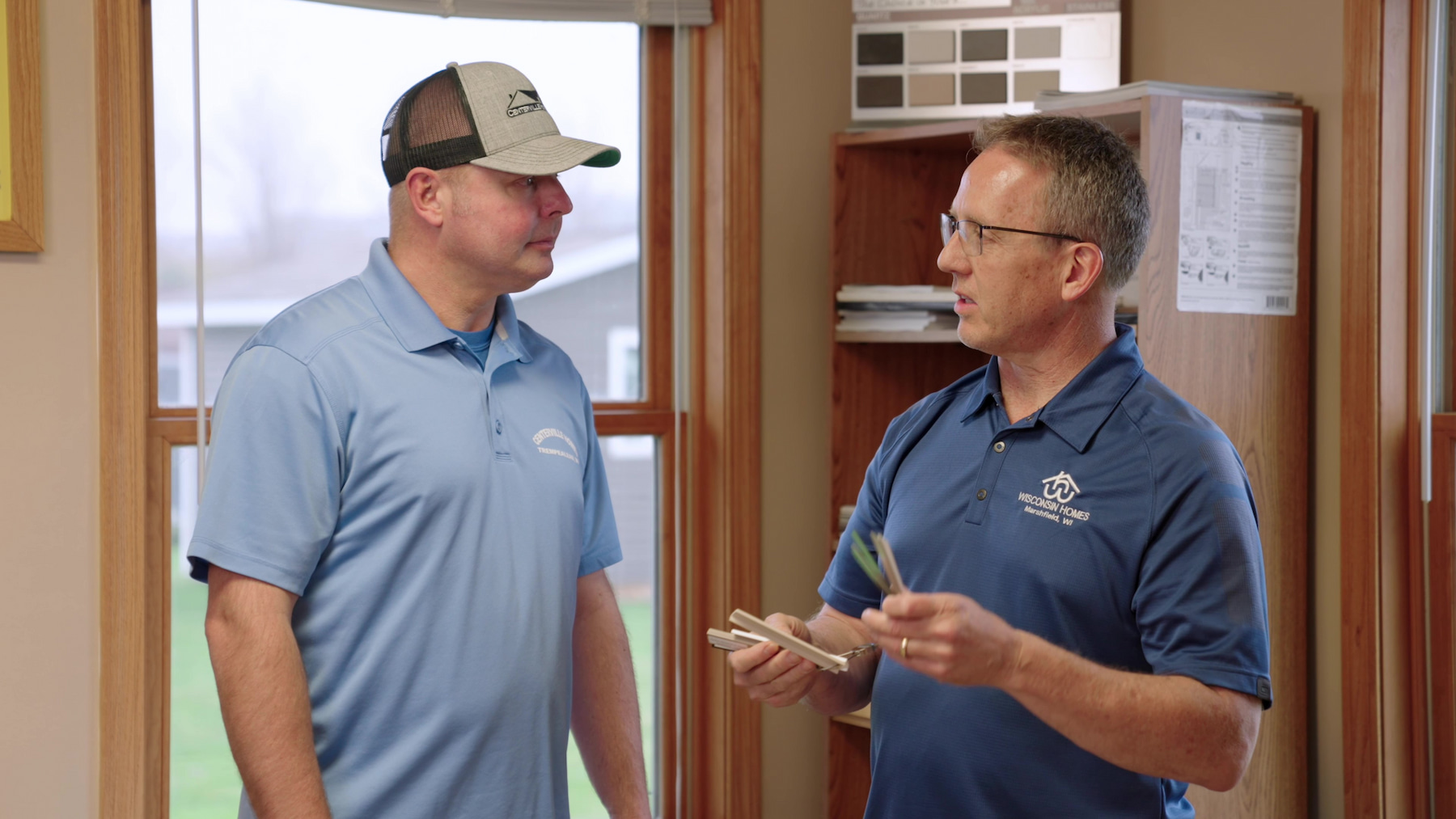 Wisconsin Homes representative discussing design samples with a customer inside the Marshfield, WI office.