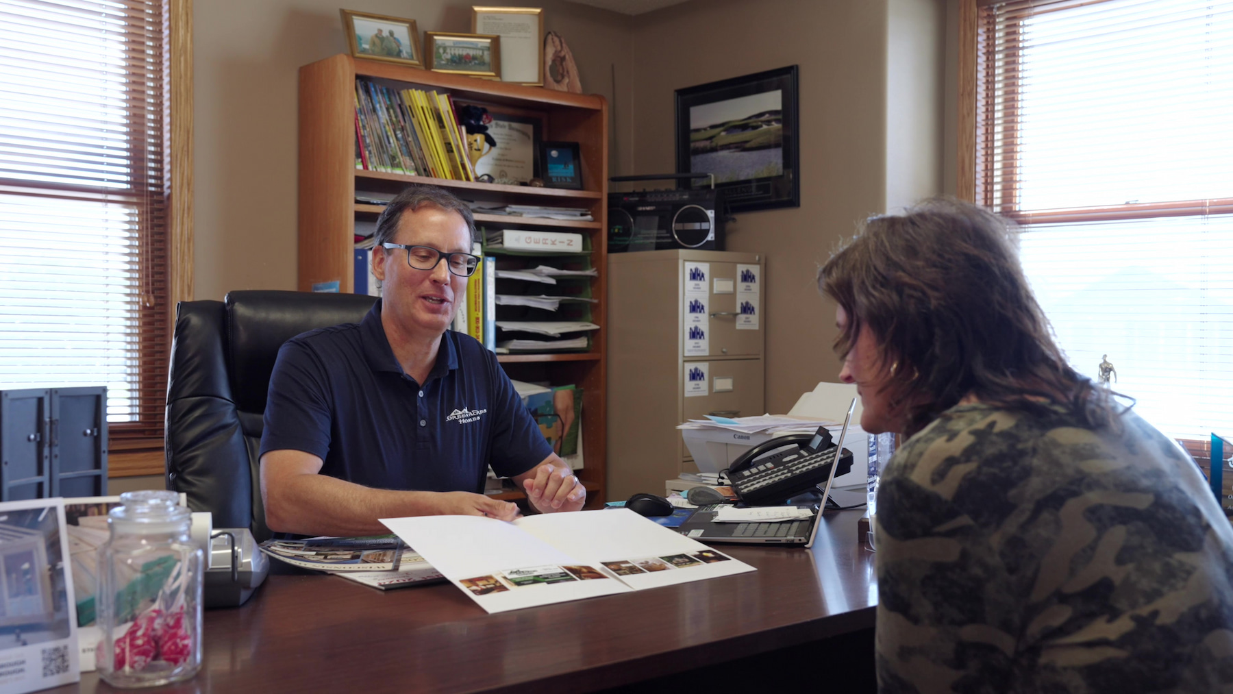 Wisconsin Homes representative reviewing home plans with a client during a design consultation in Marshfield office.