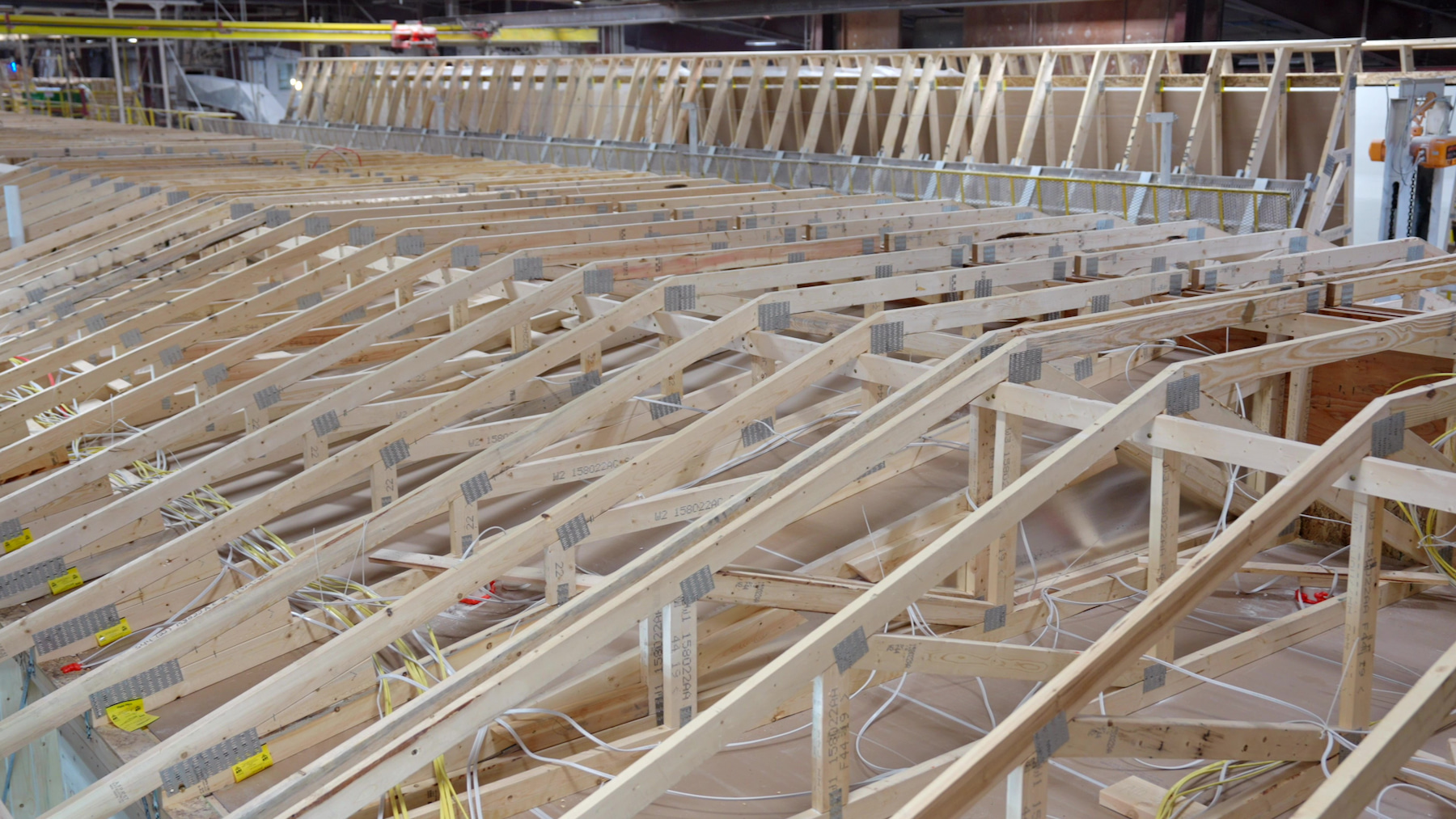 Roof trusses with integrated electrical wiring under construction at Wisconsin Homes modular facility.