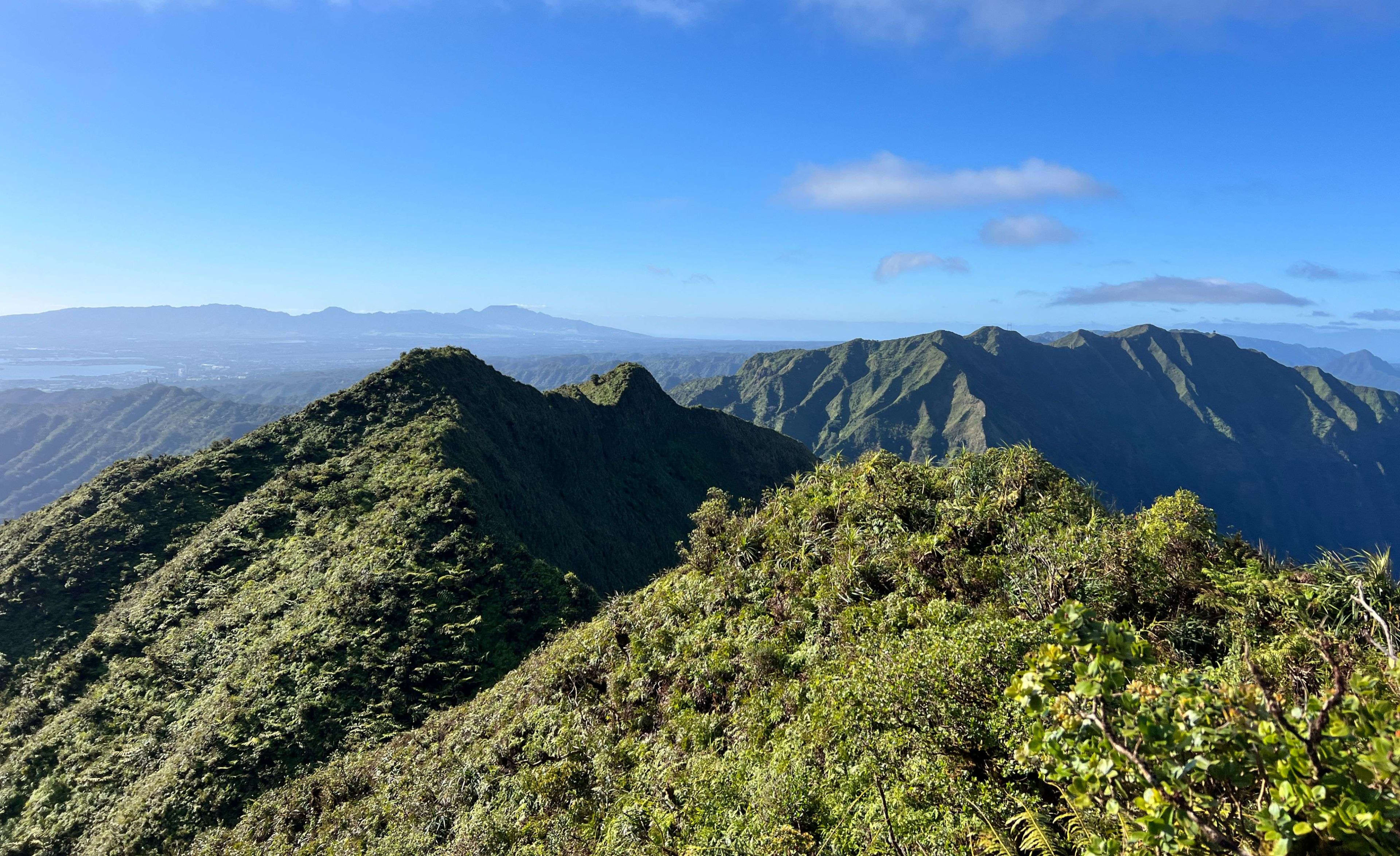 Aerial view of a Hawaiian mountain range meeting the ocean