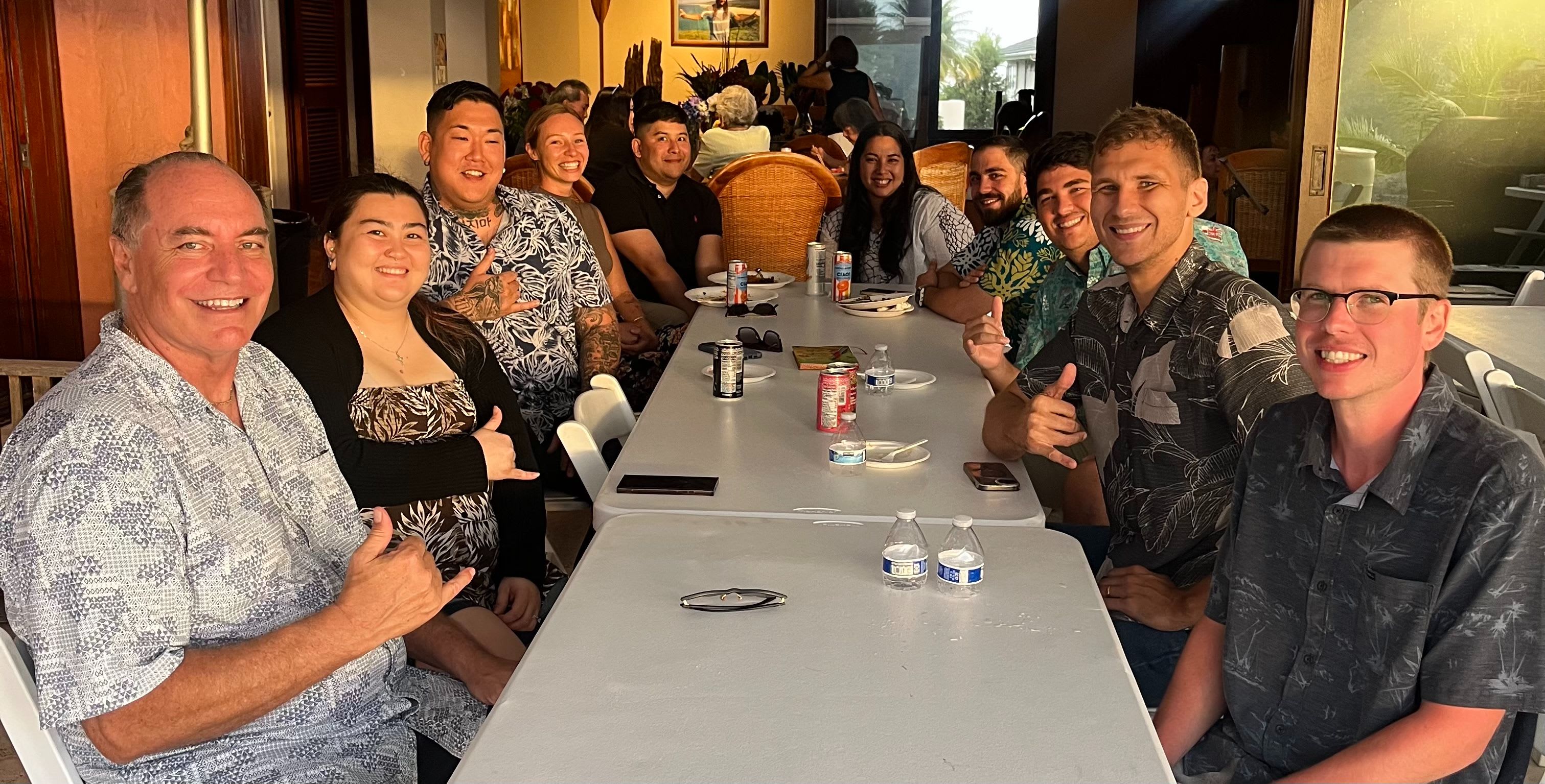 A group gathered around a long table, sharing a meal