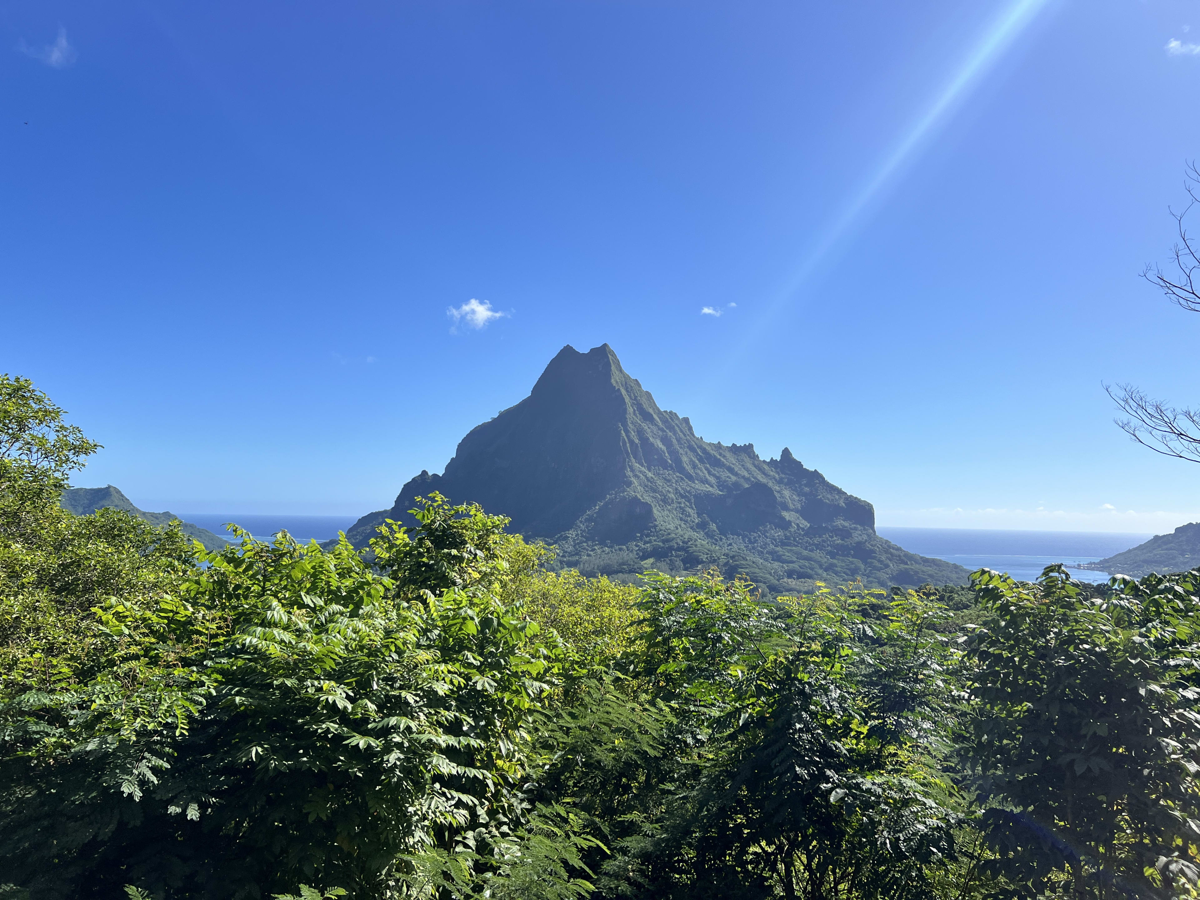 A sharp island peak rising over a turquoise lagoon