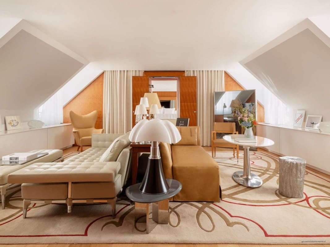 Das Wohnzimmer einer Dachgeschoss-Suite mit Schrägen und hellem Holz
