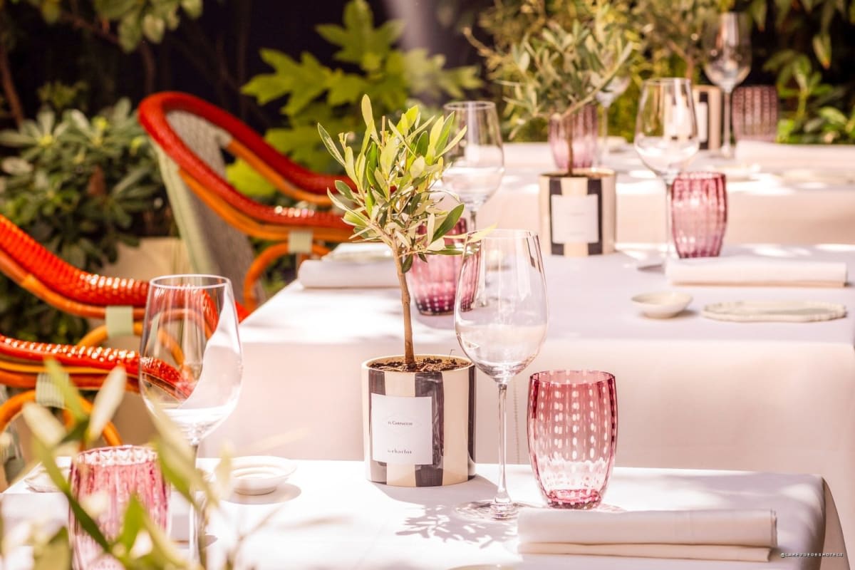 Ein gedeckter Tisch im Hotelgarten unter Bäumen