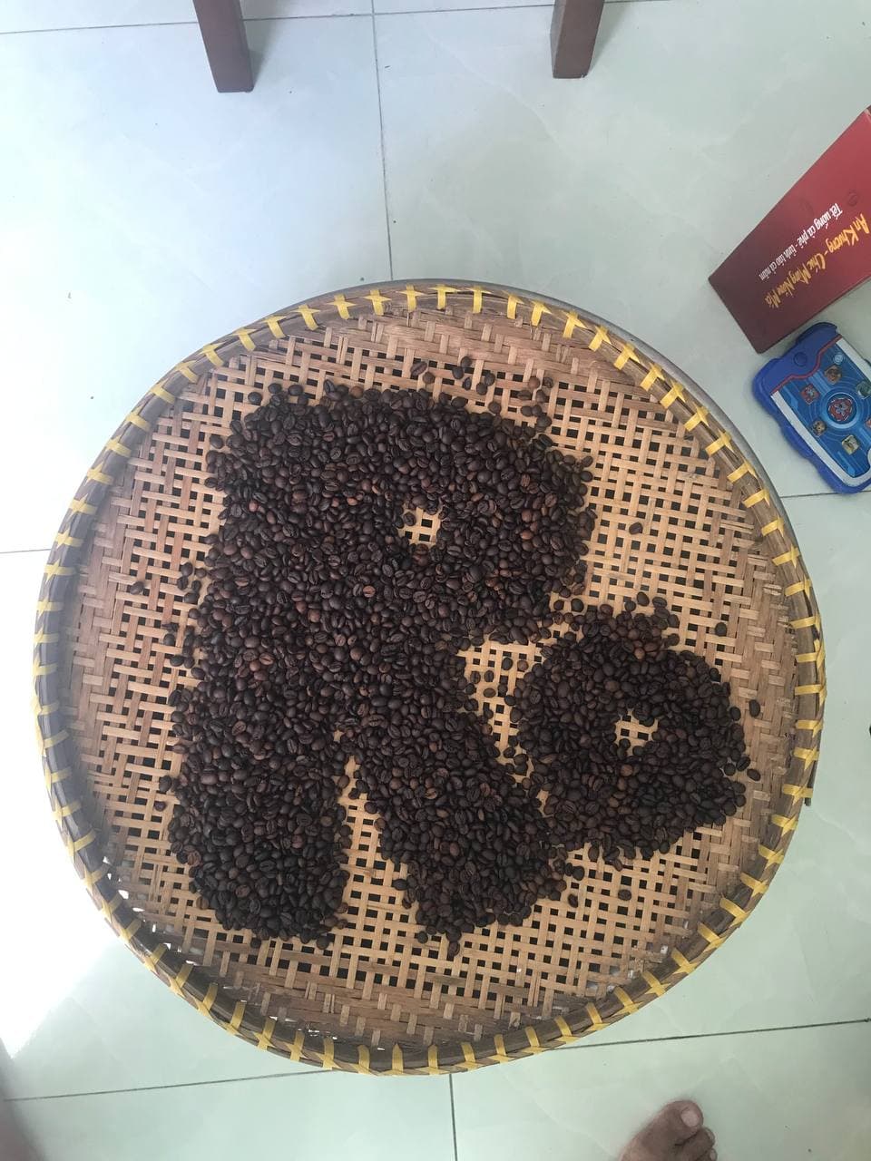 Cùng ý tưởng hạt cà phê xếp hình hoặc tạo biểu tượng trên mẹt tre, chụp rộng.