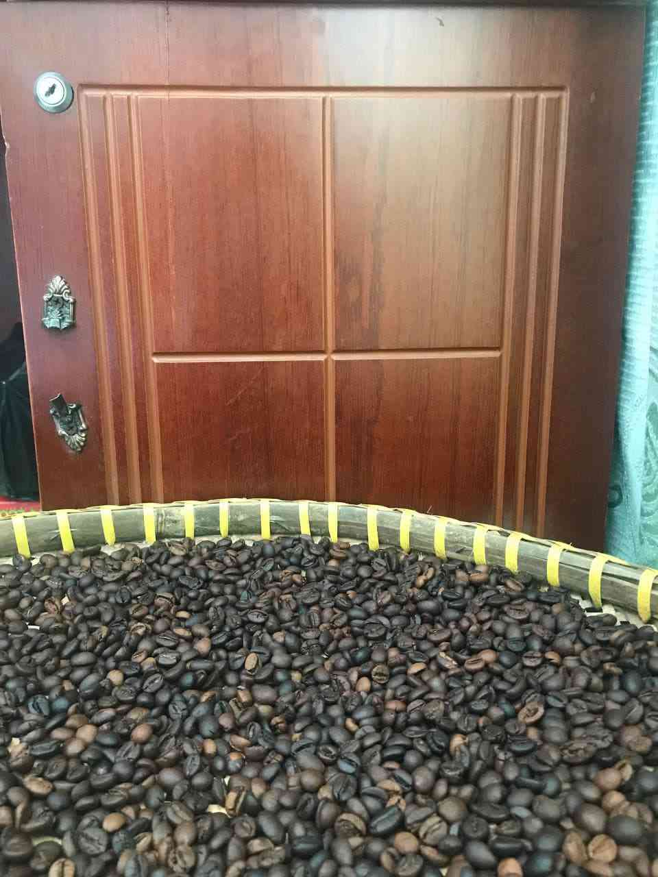 Mẹt lớn chứa hạt cà phê rang, chụp rộng.