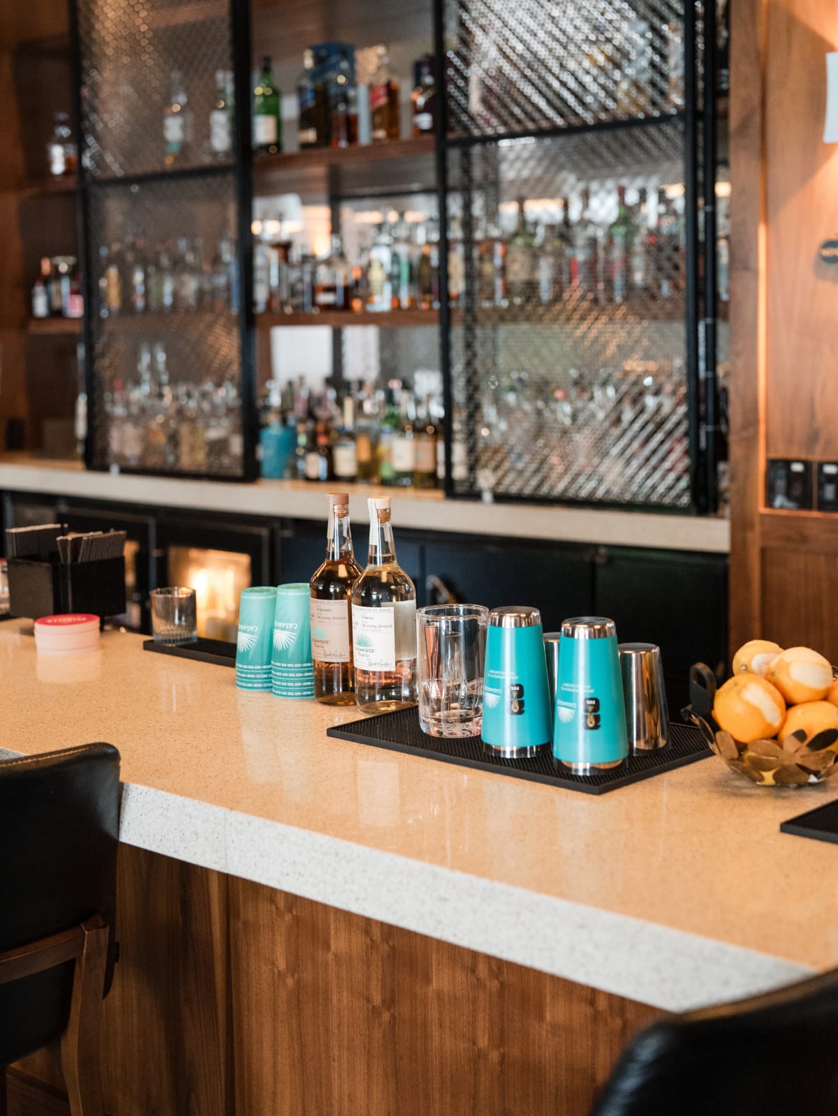 Back bar lined with bottles, Casamigos cans and cups