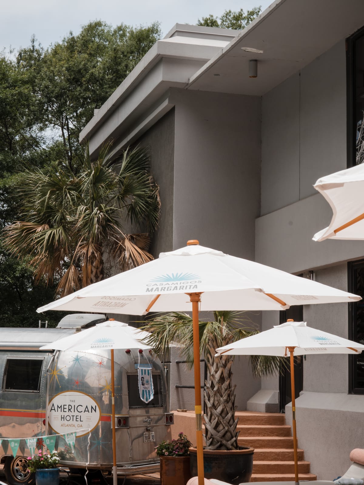 White umbrellas and palms outside The American