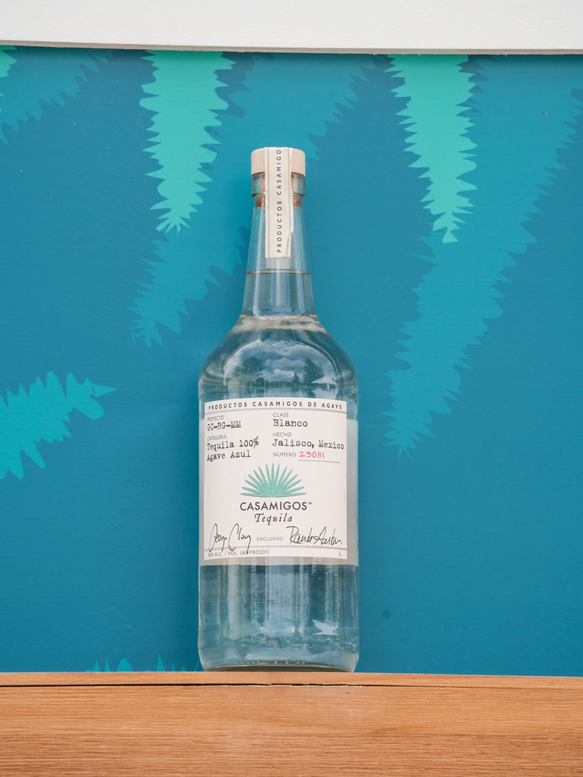 A bottle of Casamigos Blanco against the teal fan backdrop