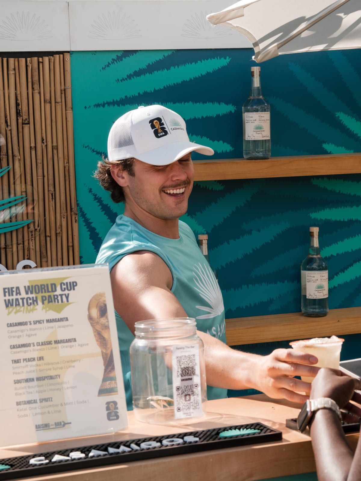 Brand ambassador handing a margarita across the Casamigos bar