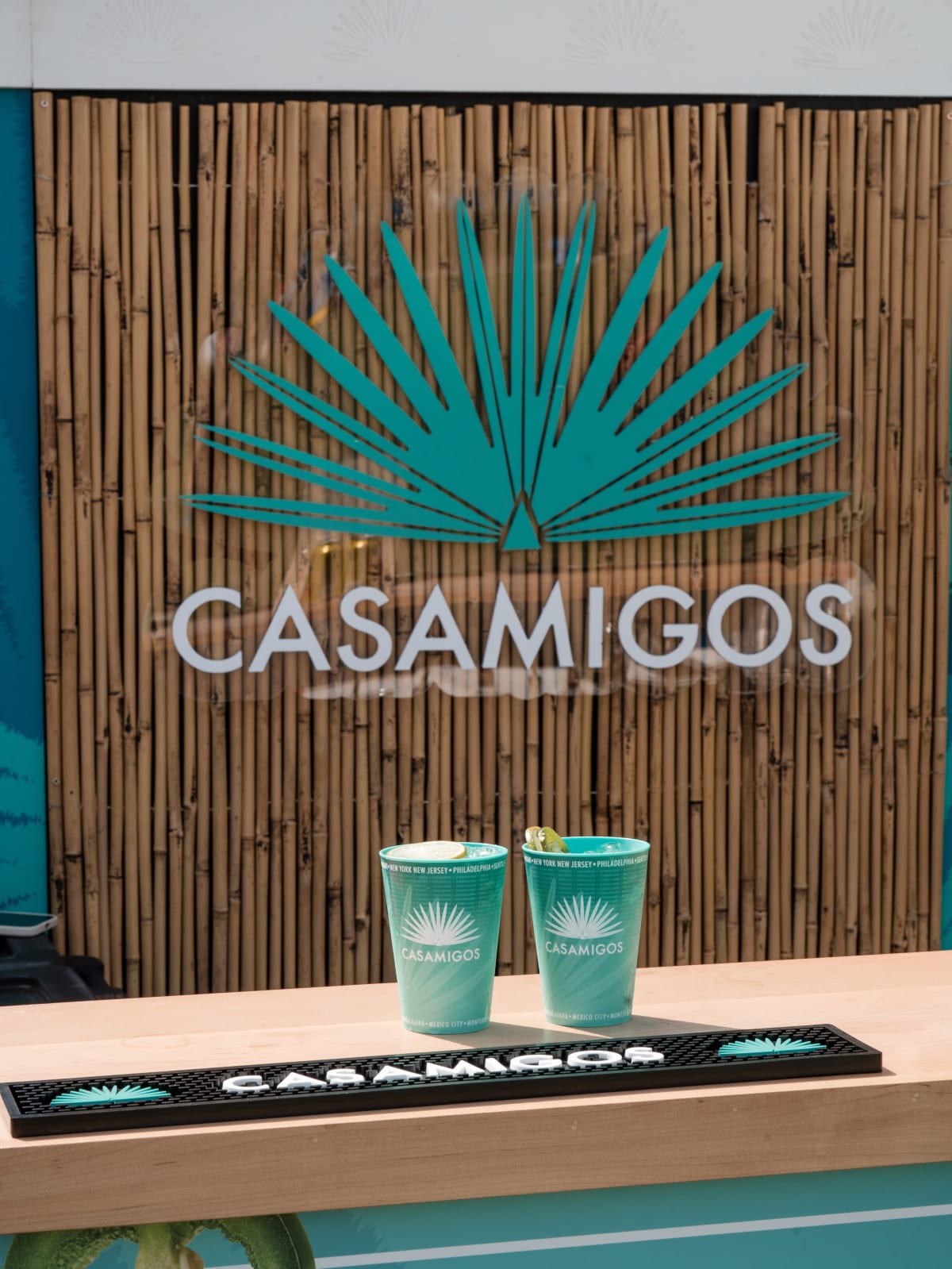 Two teal Casamigos cups on the bamboo bar top