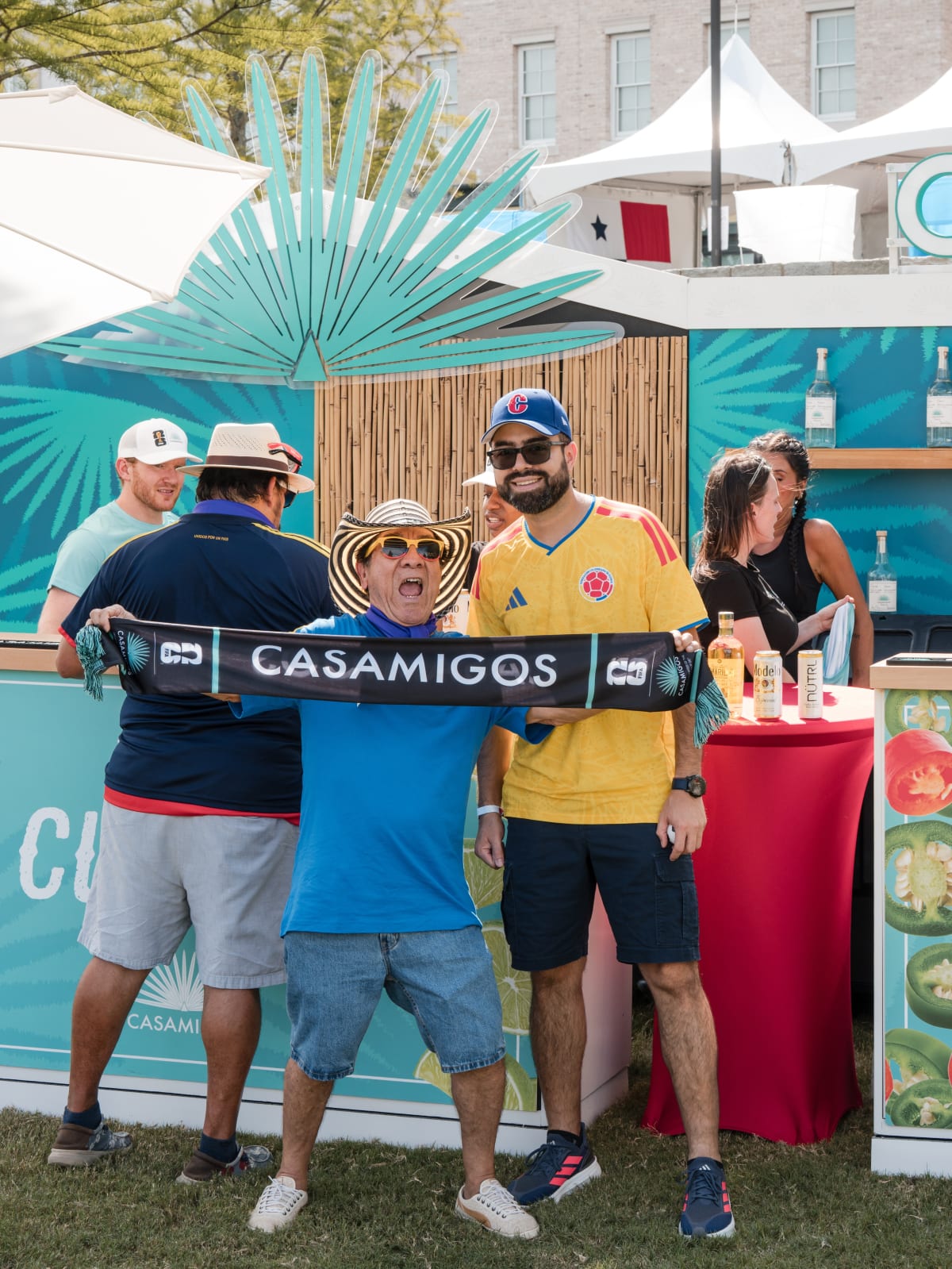 Four guests posing in front of the Casamigos booth