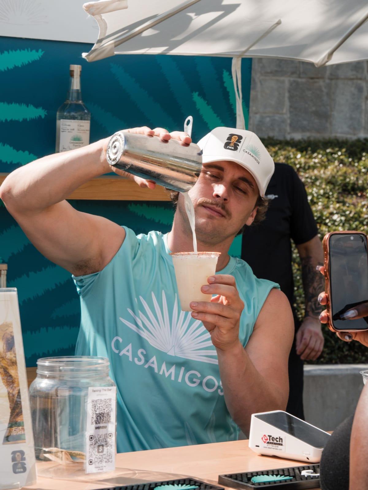 Brand ambassador pouring a margarita from a shaker into a cup