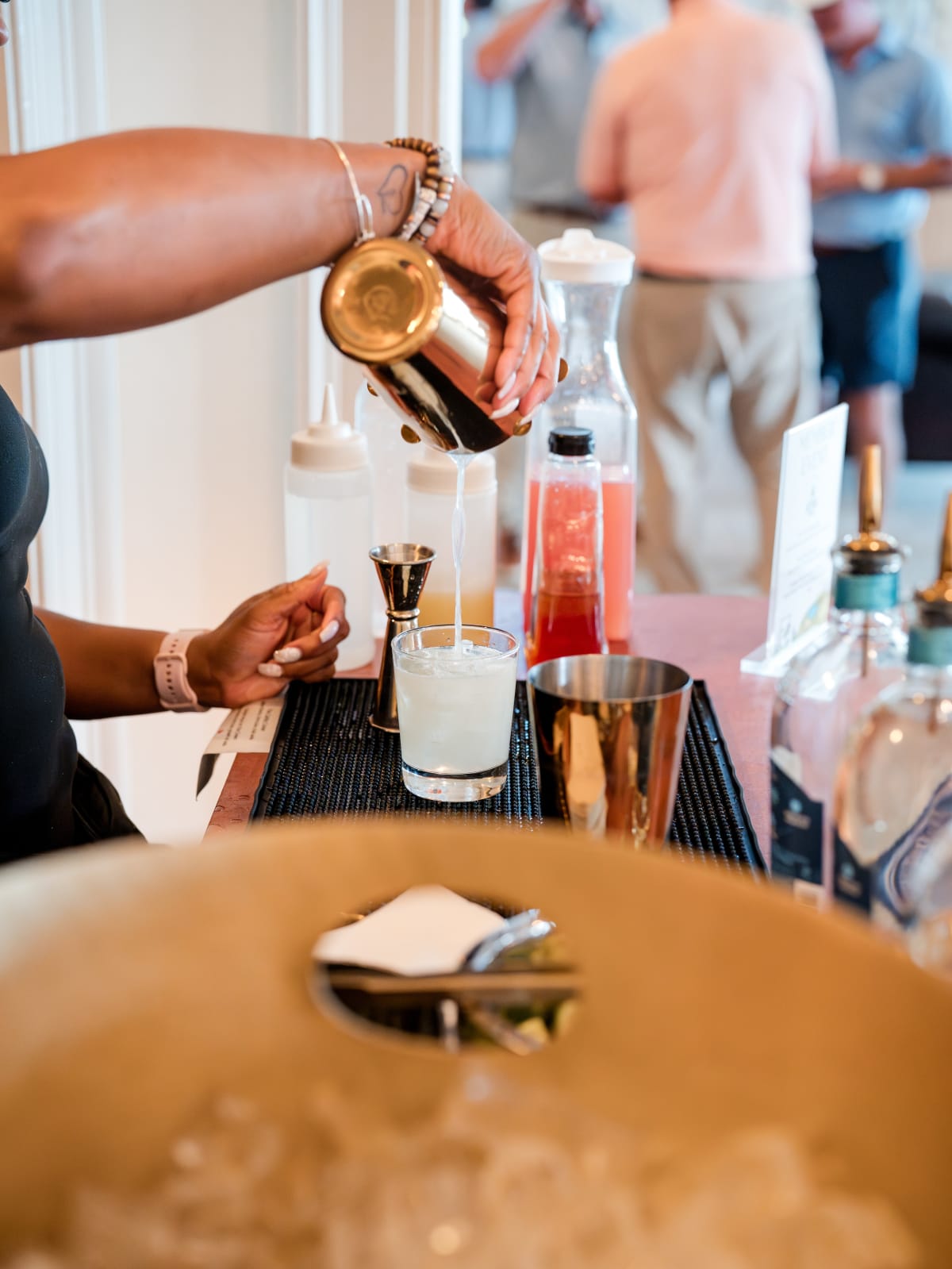 Bartender pouring a cocktail from a shaker at the Astral bar