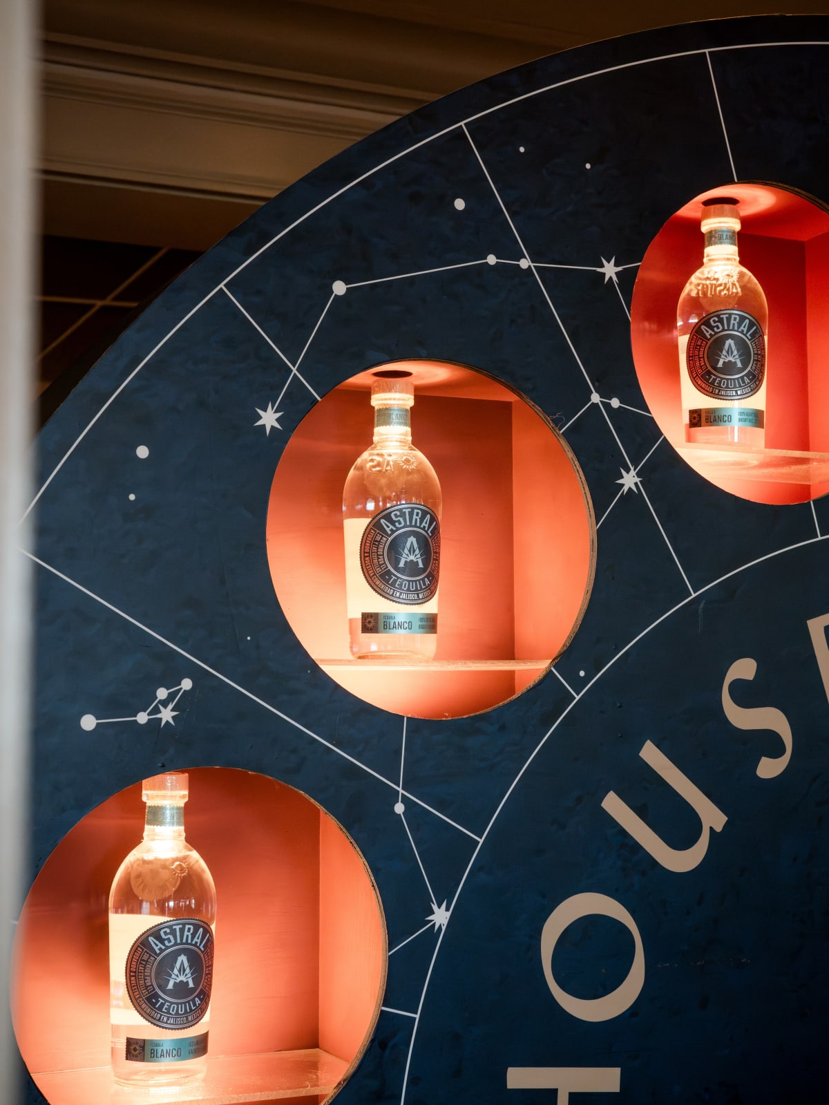Astral bottles lit in a constellation display wall
