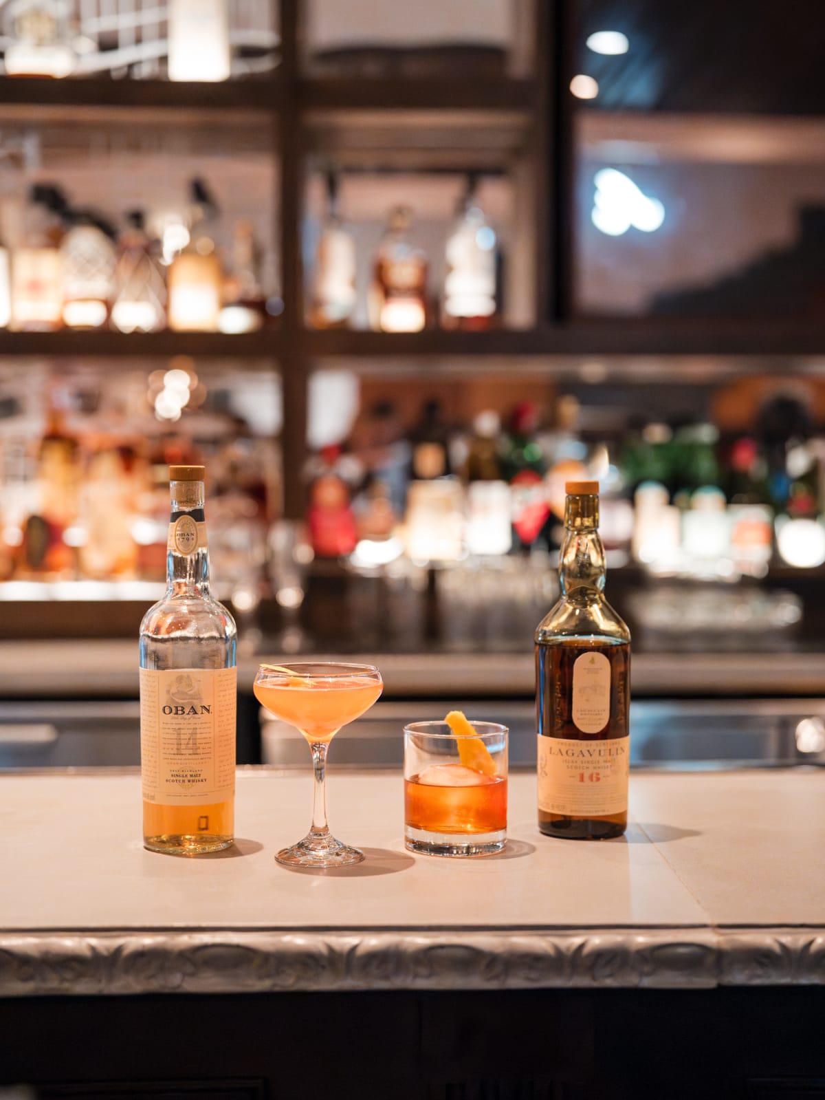 Bottles and finished serves lined up on the back bar