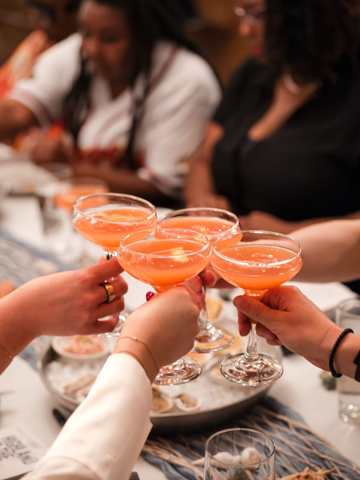 Guests raising cocktails in a toast at the table