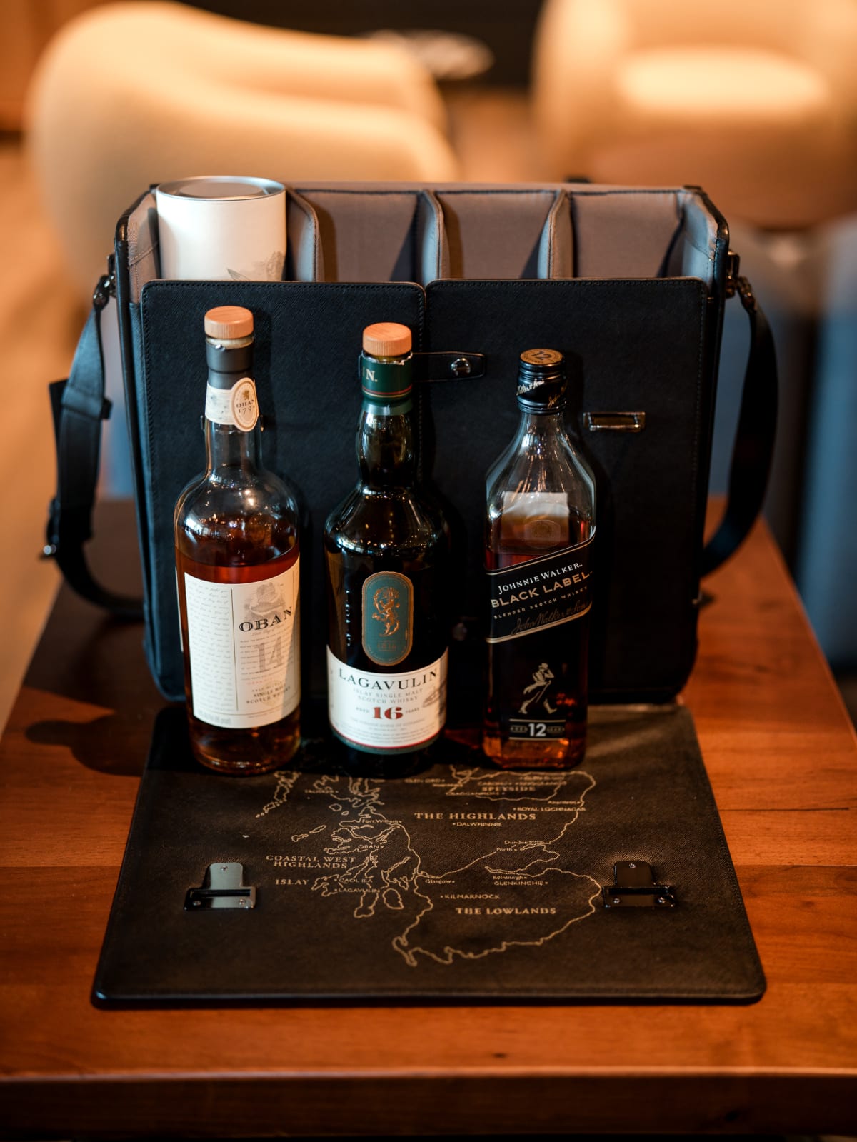 Three-bottle flight case open on a map of the Scotch regions