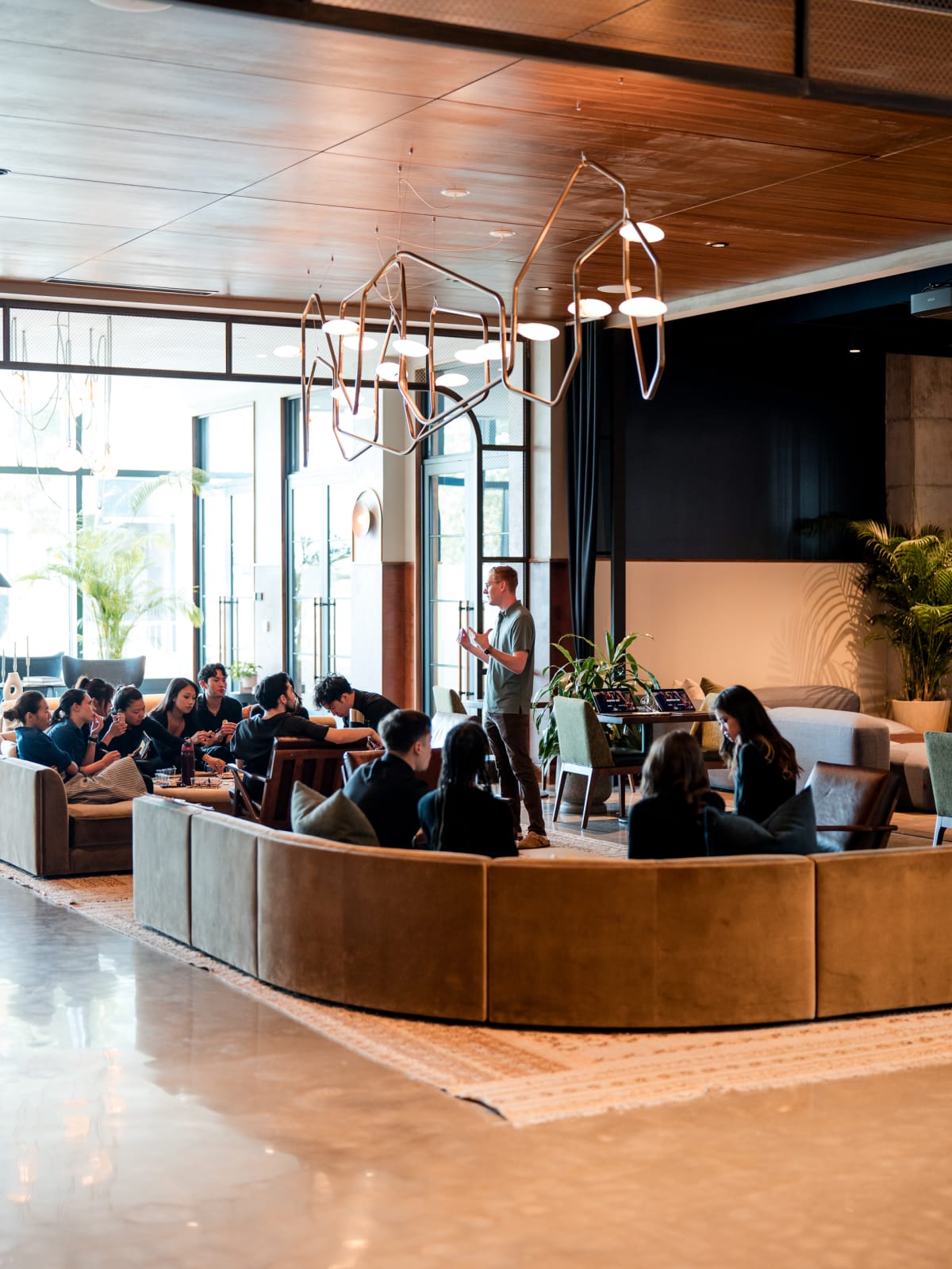 The full room seated and listening on the curved banquette