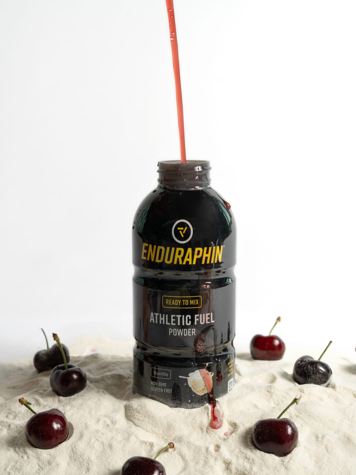 Cherries and powder around the cherry flavor bottle