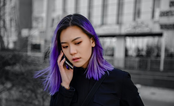 Wanita berambut ungu sedang menelpon pasangan saat long distance relationship