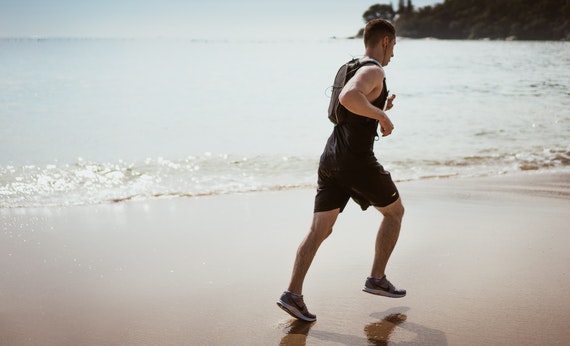 Pria jogging di pantai