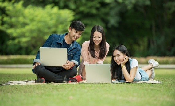 Tiga orang sedang belajar di taman