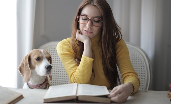 Woman in yellow sweater while reading a book