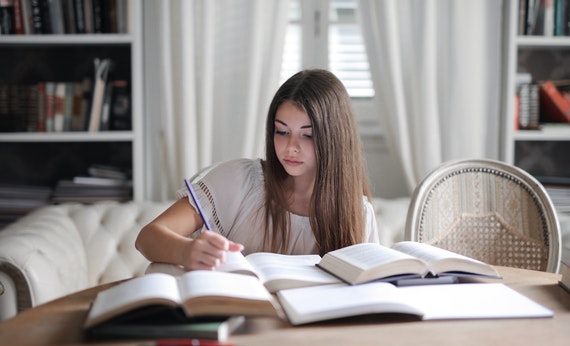 Woman in gray long sleeve shirt reading book