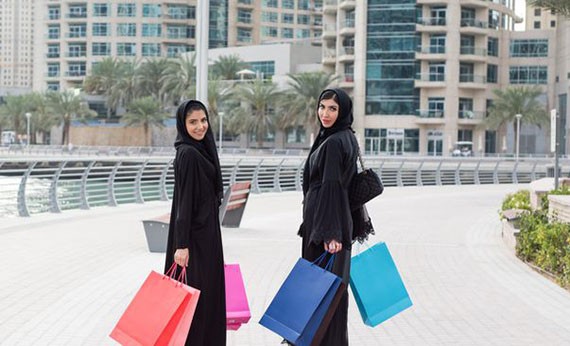 Dua wanita muslim berbelanja menggunakan pakaian warna hitam
