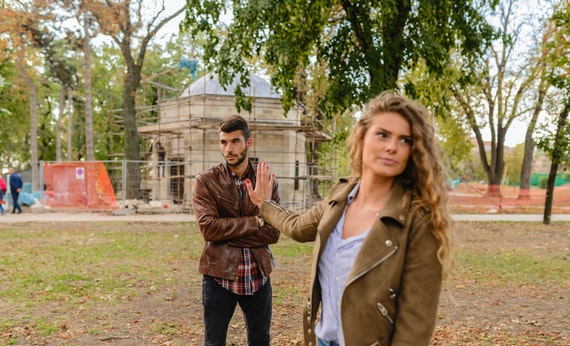 man and woman brown leather coat standing on brown soil